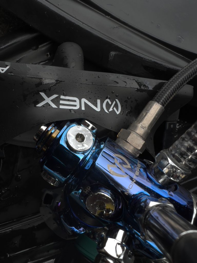 Close-up of a bike handlebar with XENON branding and metallic blue components.